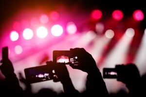 silhouette-hands-using-smartphones-take-pictures-videos-live-music-show